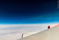 Bildausschnitt eines Flugzeugflügels über den Wolken
