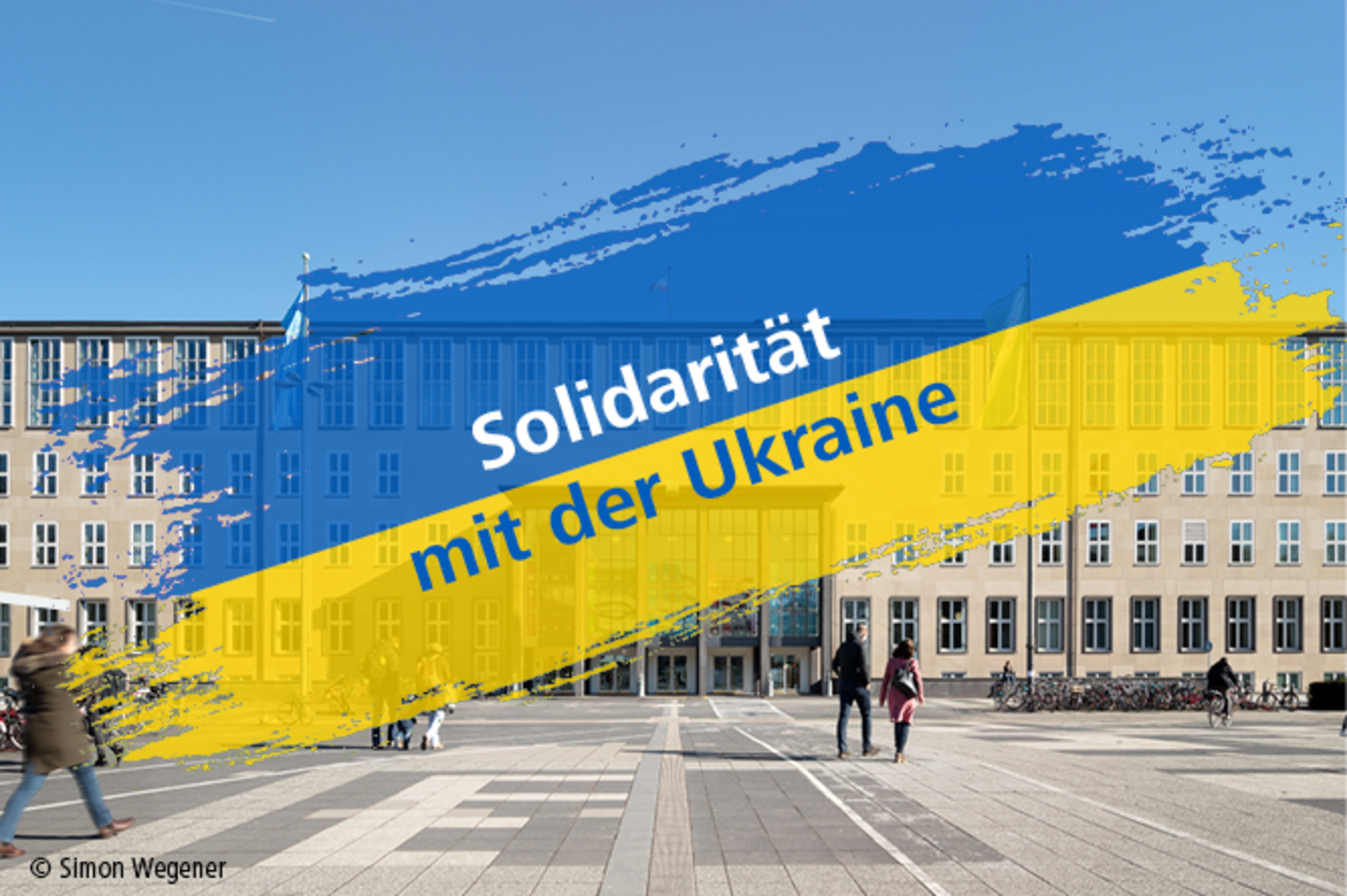 Hauptgebäude der Uni Köln und Schriftzug "Solidarität mit der Ukraine" auf den Farben der ukrainischen Flagge