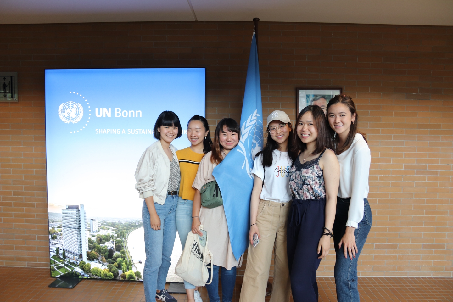 Six students with the flag of the united nations.