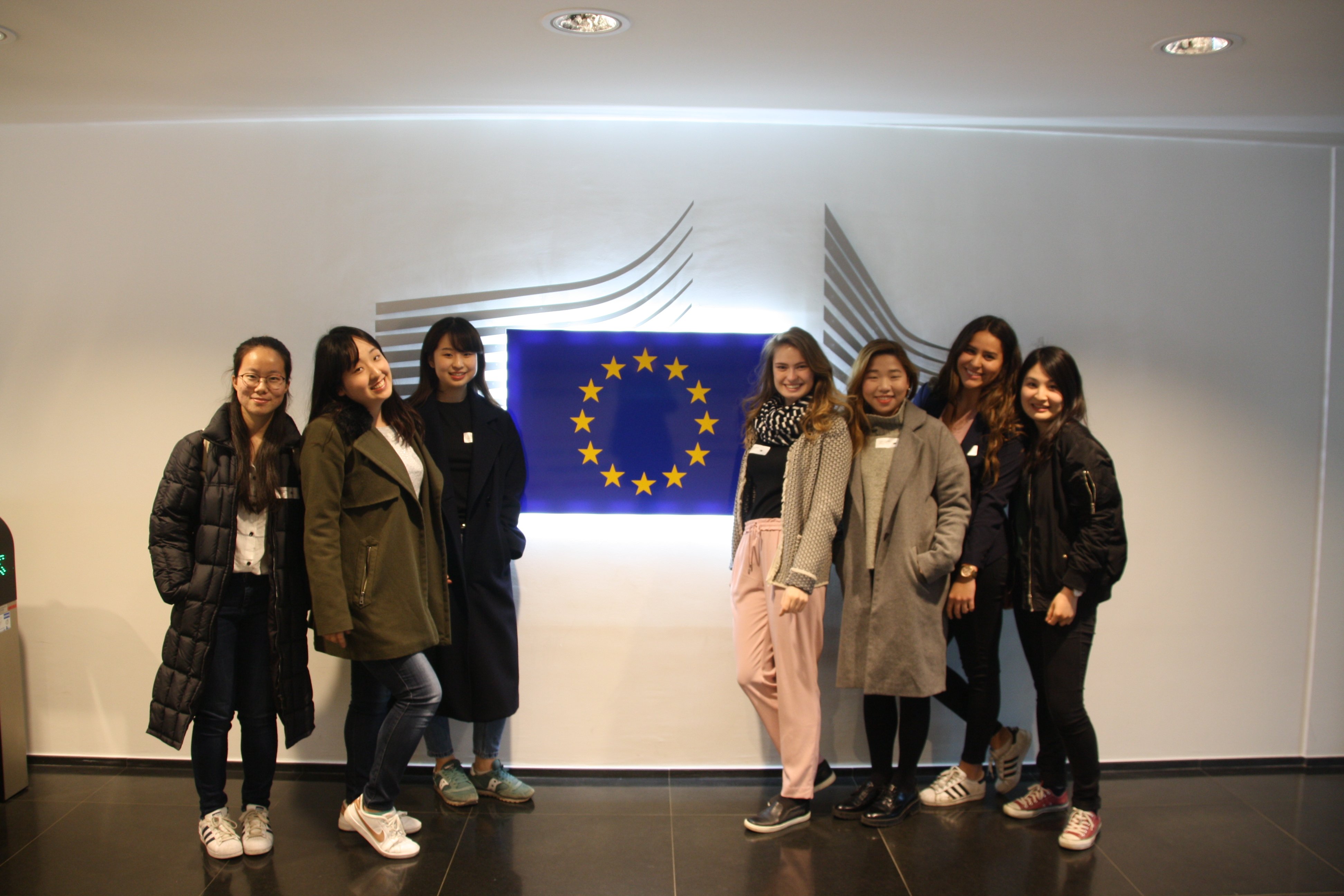 Students standing next to the logo of the European Commision