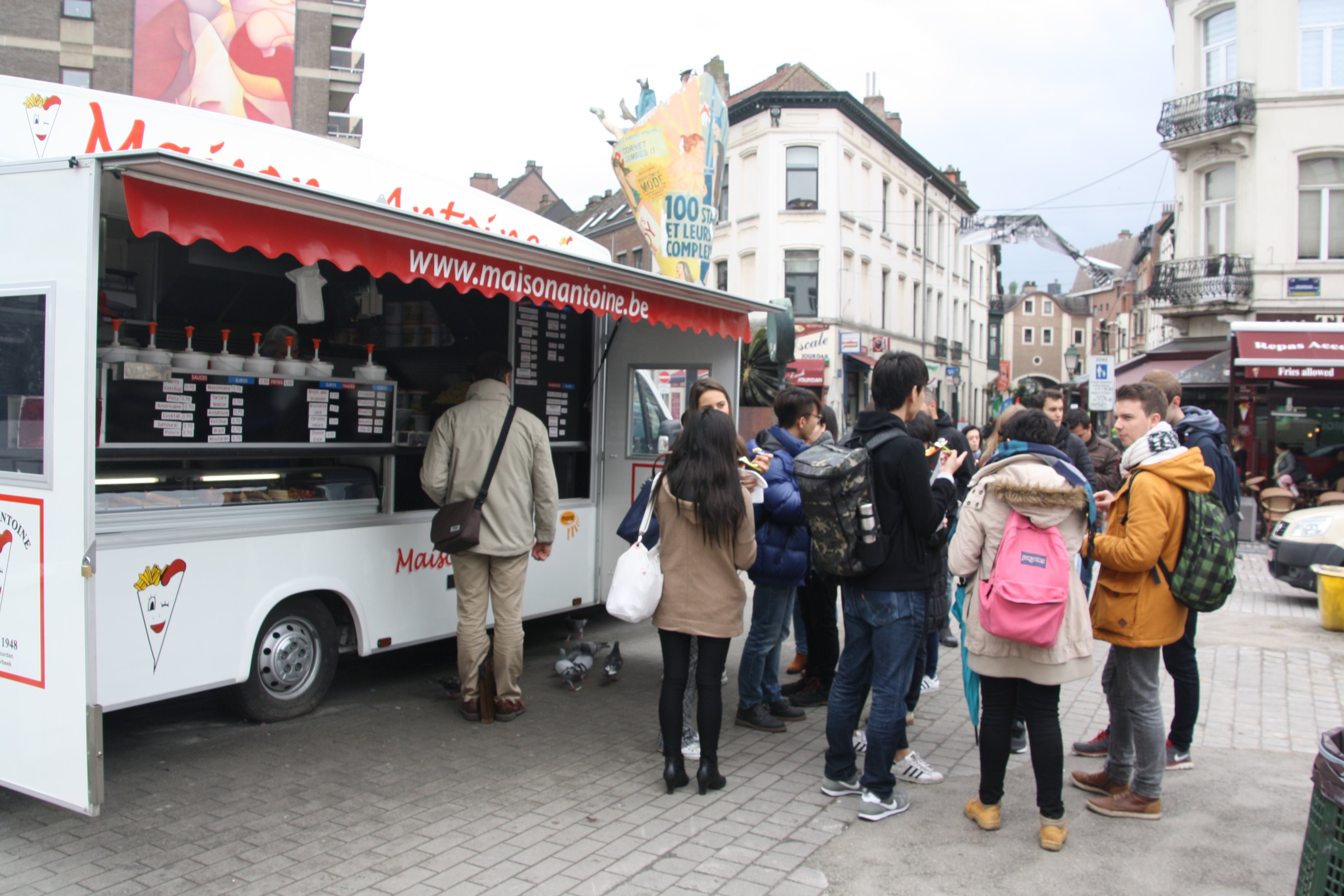 Group of students in front of a belgian fries food truck.