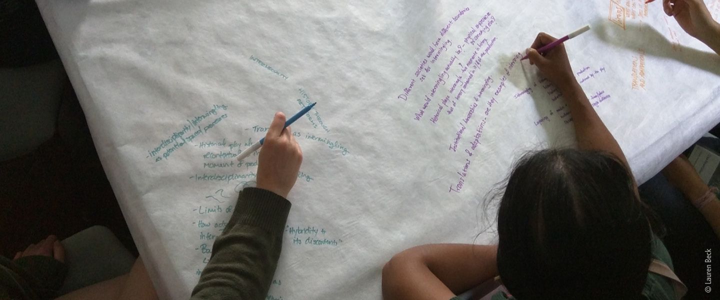 Students write on a large poster
