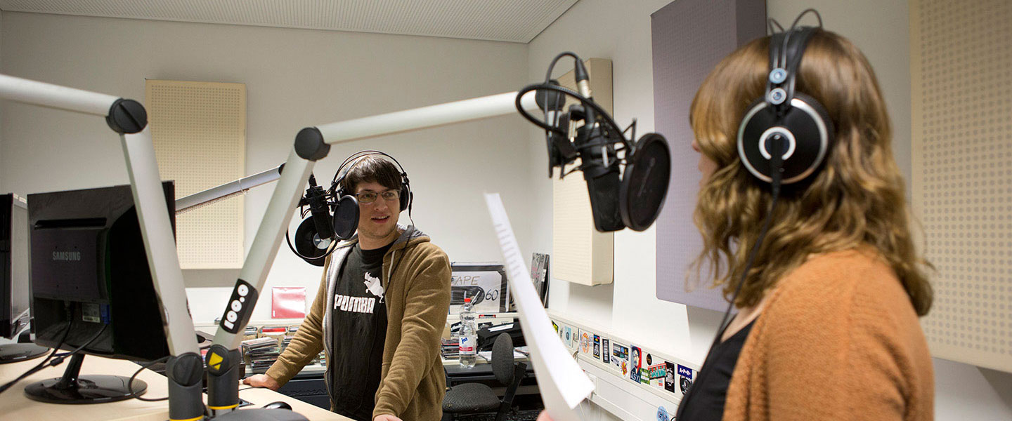 Studentin und Student moderieren in einem Rundfunkstudio